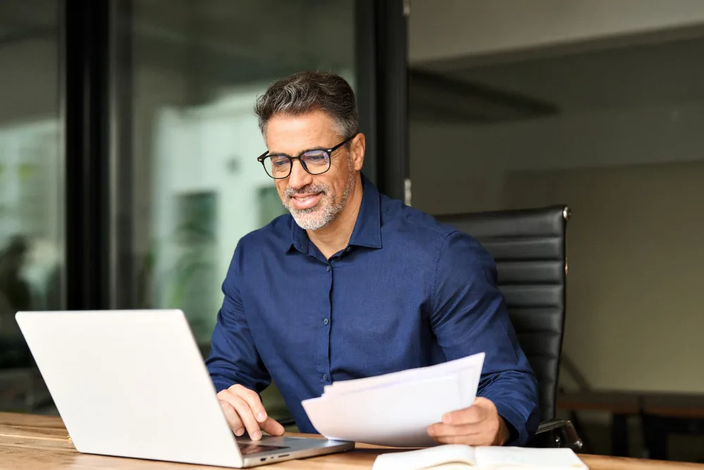 Manager werkt aan medewerkermotivatie onderzoek op zijn laptop